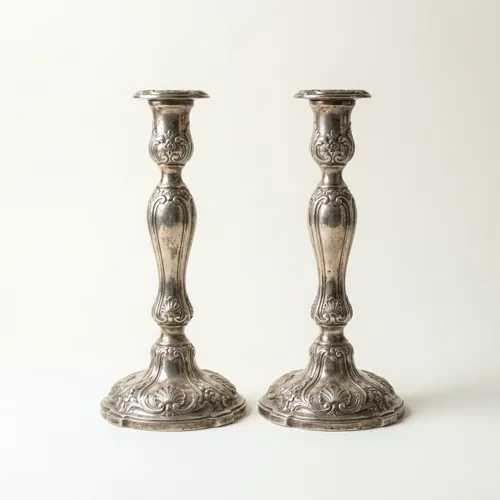 A pair of repoussé silver candlesticks on domed circular feet