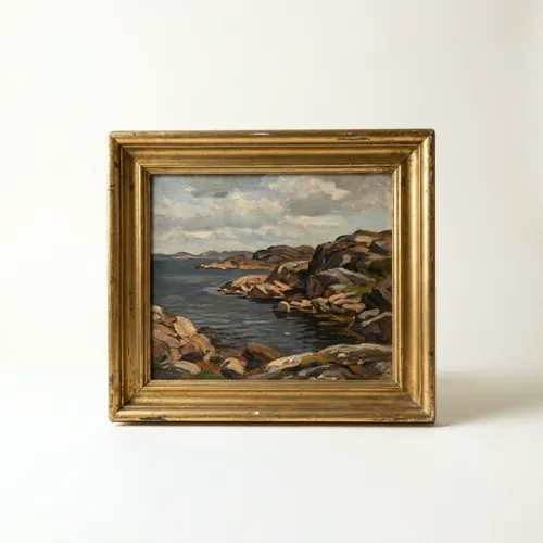 An oil painting of a rocky Nordic coastline in a gilt frame
